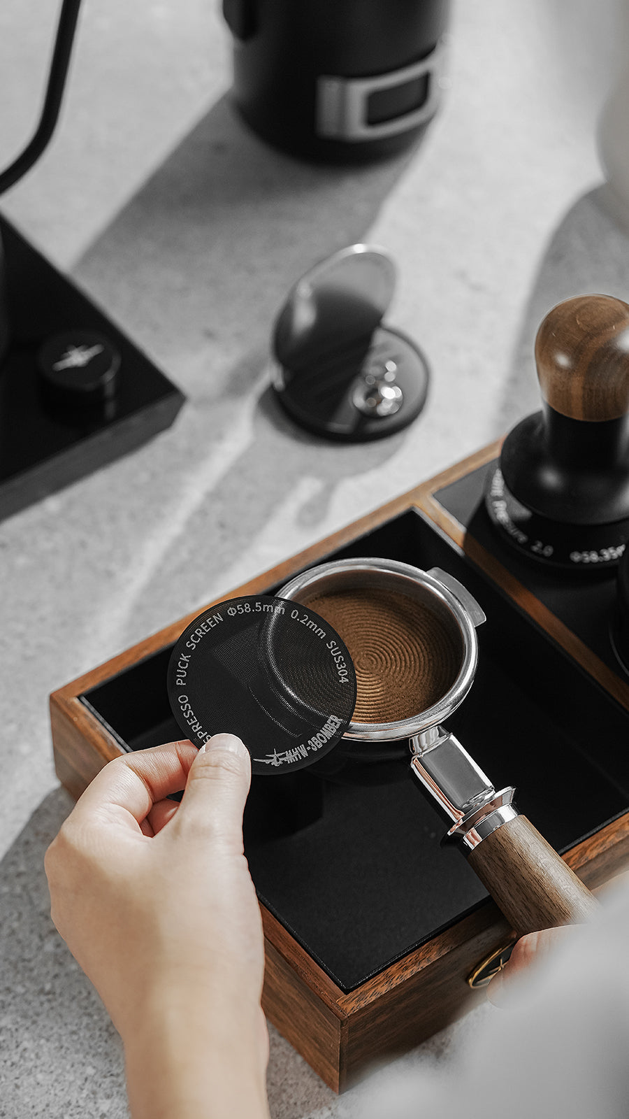 MHW-3BOMBER FG5642 58.5mm 0.2mm black puck screen held beside a basket at a coffee station; props not included