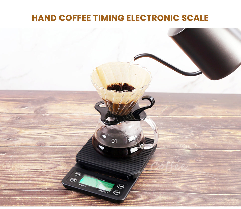 HiBREW black four-button green-LCD timer coffee scale — pour-over demonstration on wooden table. Kettle, dripper, server, filters and coffee are demonstration props, not included.