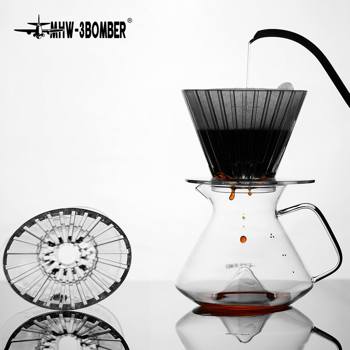 MHW-3BOMBER FC6605 — clear Oval dripper brewing on a server with a second clear dripper alongside; other tools are scene props