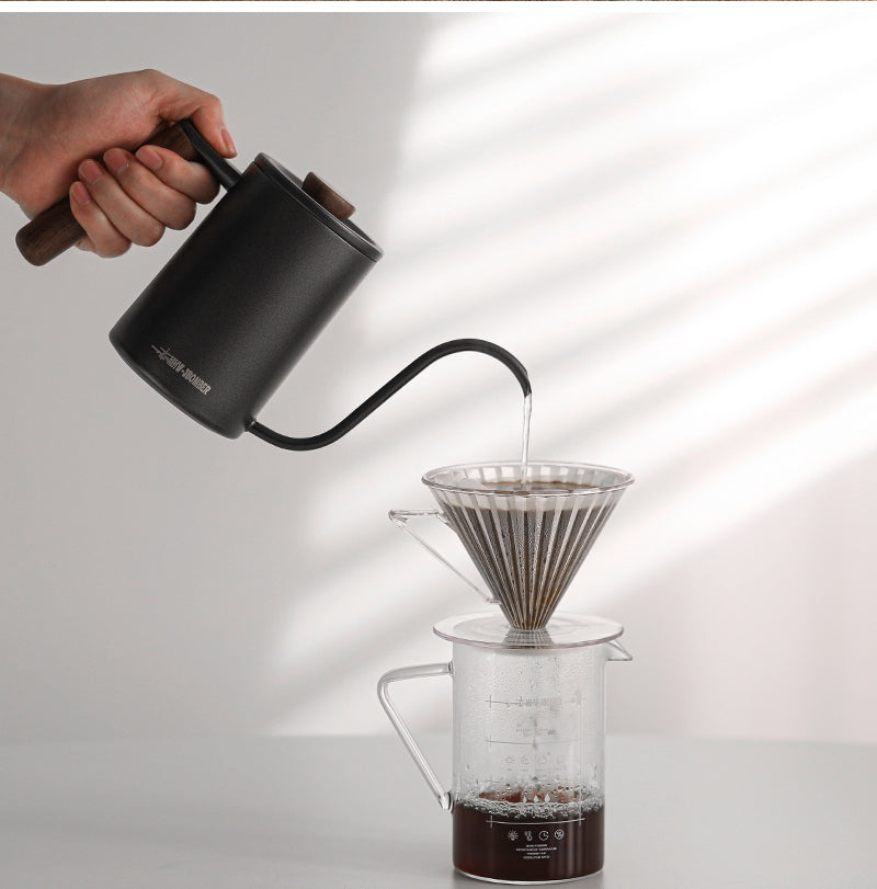 MHW-3BOMBER black cylindrical Planet kettle pouring into a dripper beside a window