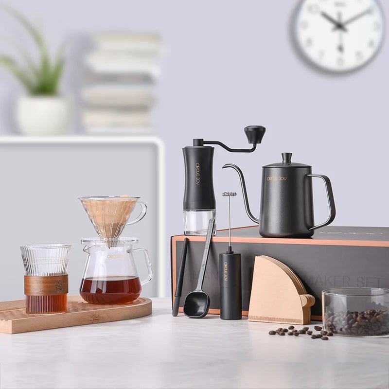 Hand grinder, gooseneck kettle and pour-over coffee tools on a home counter