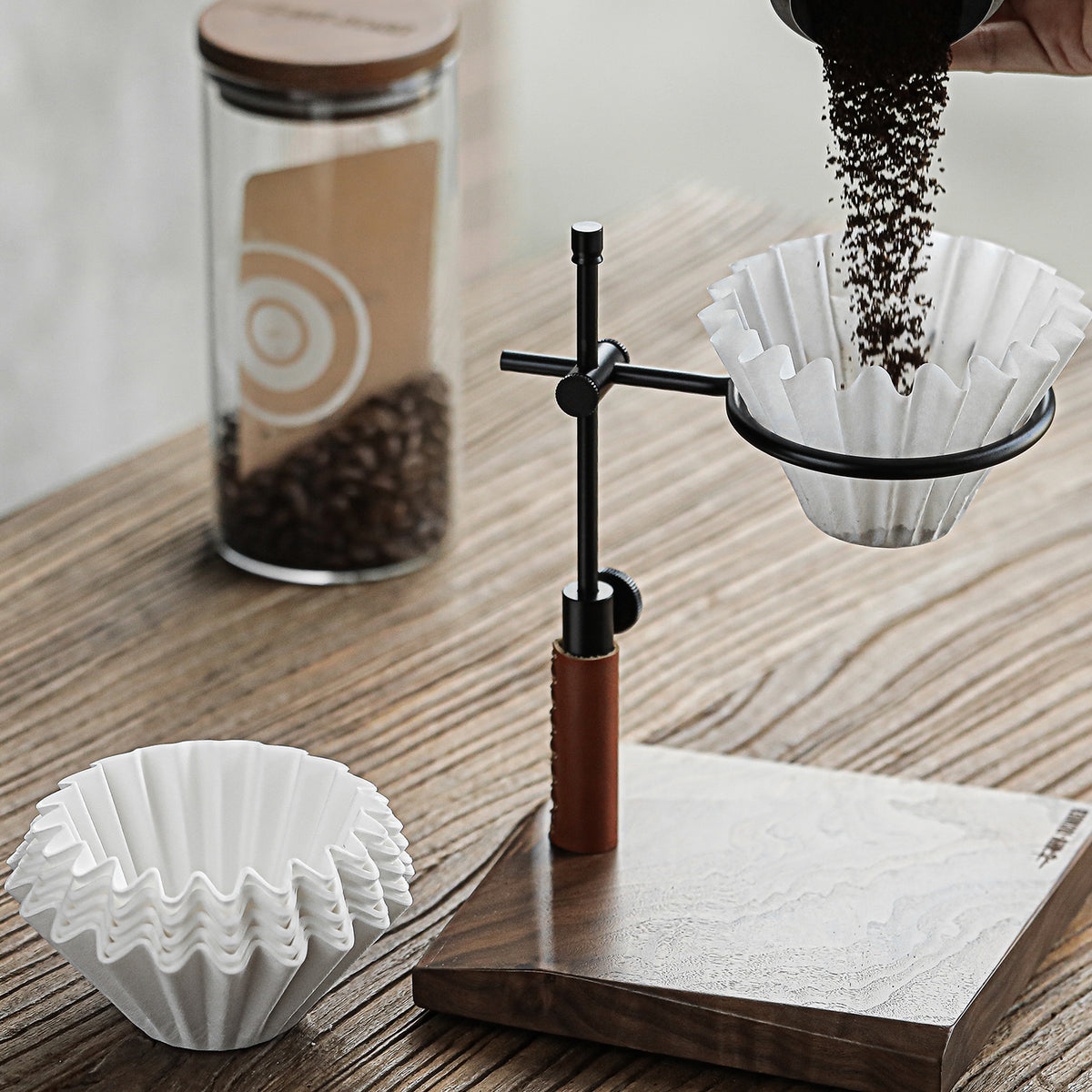 Cake-shaped filter paper beside a pour-over dripper