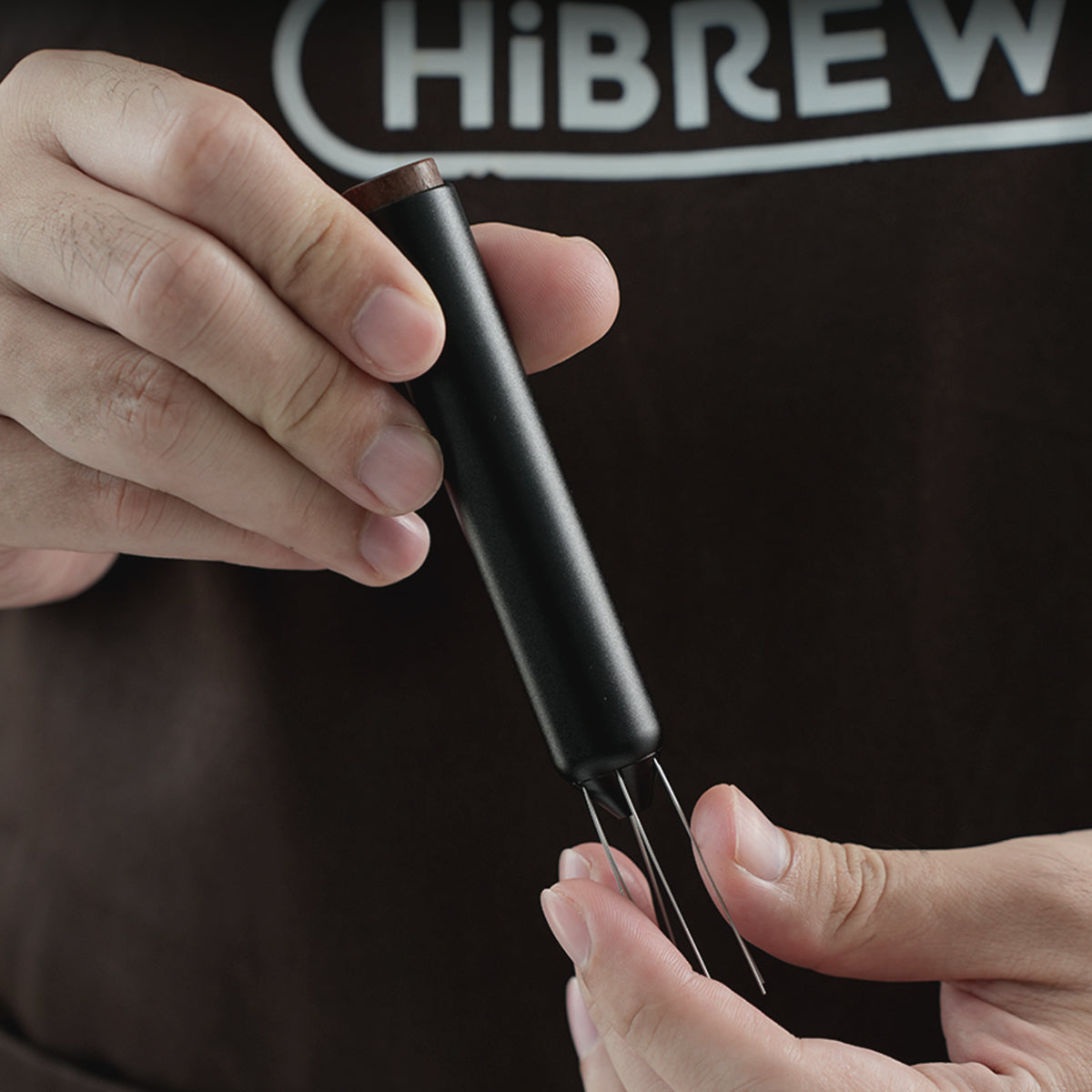 HiBREW Master Coffee WDT Tool — needle assembly and handle shown by hand. Demonstration props are not included.
