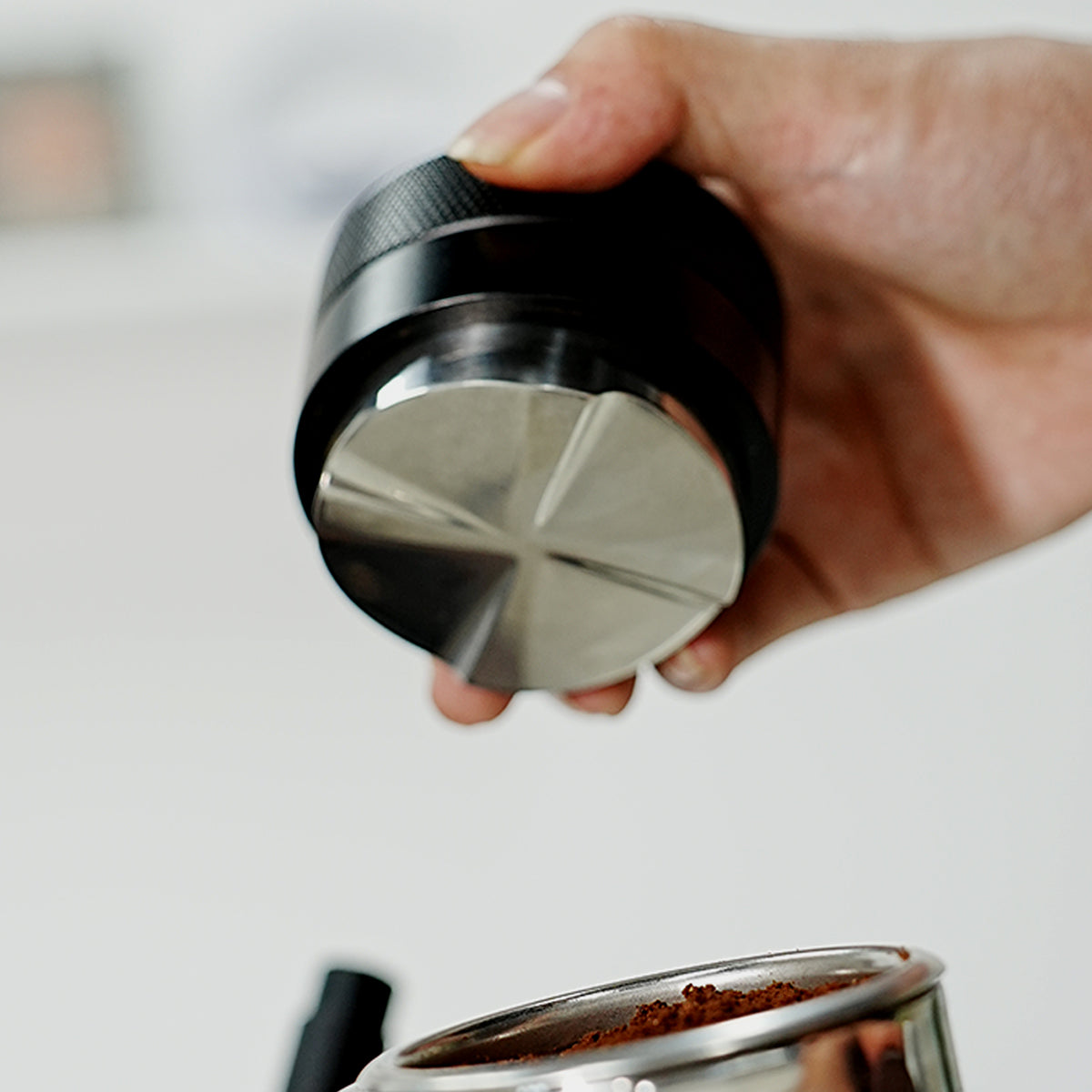 HiBREW Master 58mm Coffee Distributor — underside shown by hand above a basket. Demonstration props are not included.