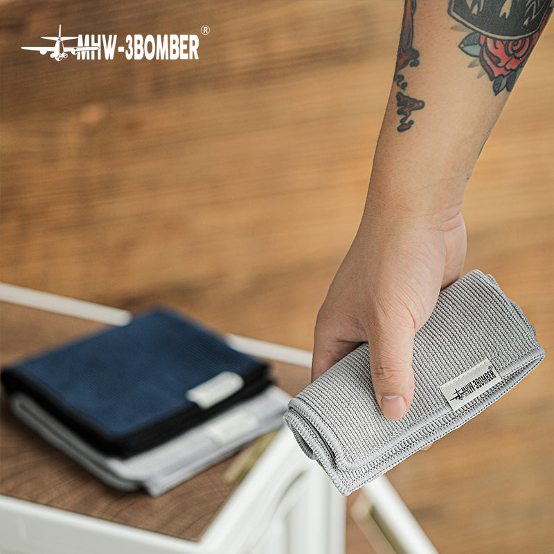Grey towel from the MHW-3BOMBER CT5322 four-piece blue and grey set held at a work surface; display does not change the quoted set quantity