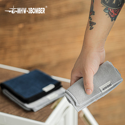 Grey towel from the MHW-3BOMBER CT5322 four-piece blue and grey set held at a work surface; display does not change the quoted set quantity