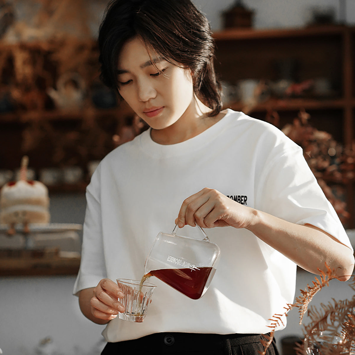 G5096 Clear server being poured into a glass by a person in a white T-shirt. Other pictured tools, coffee and props are not included.