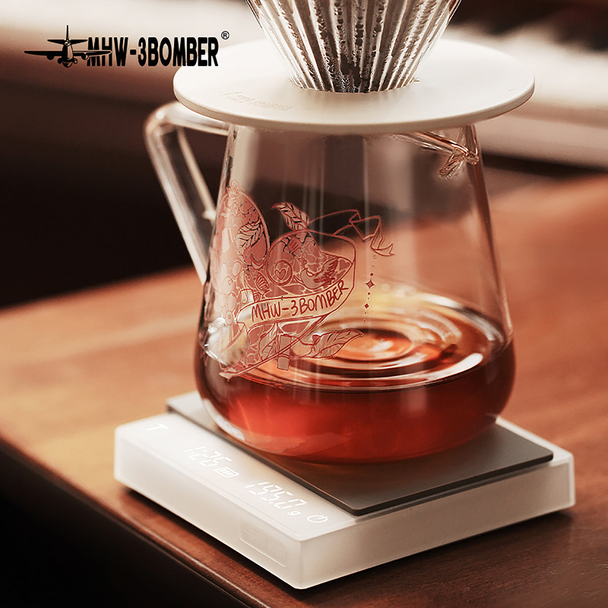 G5199P Heartbeat artwork server with coffee beneath a dripper on a white scale. Other pictured tools, coffee and props are not included.