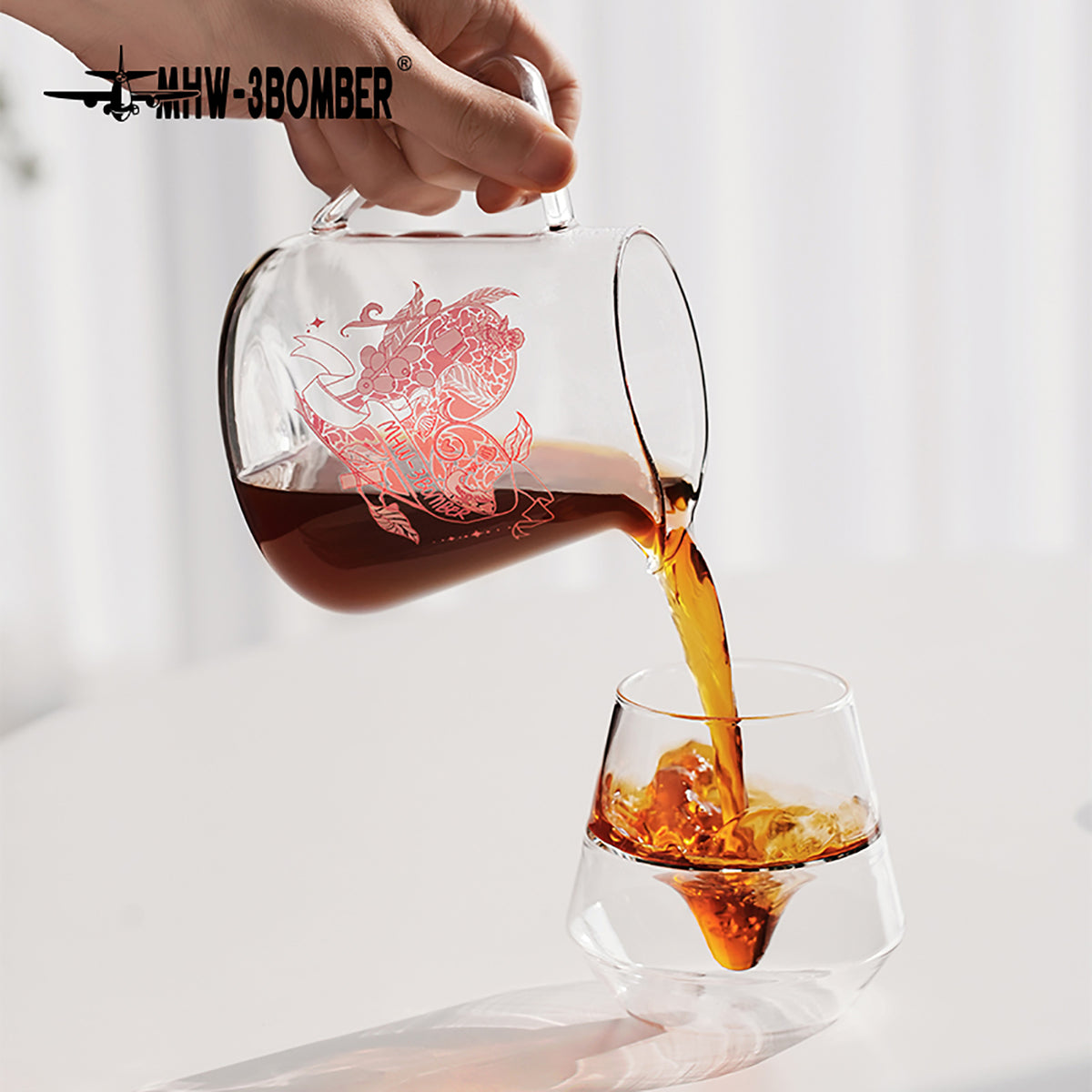 G5199P Heartbeat artwork server pouring coffee into an iced glass against a bright background. Other pictured tools, coffee and props are not included.