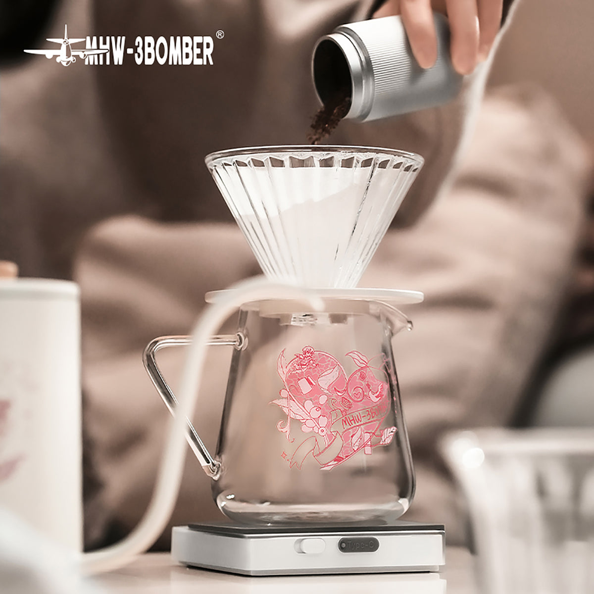G5199P Heartbeat artwork server beneath a filter while coffee grounds are added. Other pictured tools, coffee and props are not included.