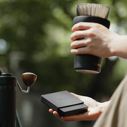 MHW-3BOMBER Cube Coffee Scale 3.0 Mini Pro, black — ES6029B — outdoor platform; brewing accessories are scene props