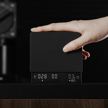 MHW-3BOMBER Cube Coffee Scale 3.0 Mini Pro, black — ES6029B — upright handheld; brewing accessories are scene props