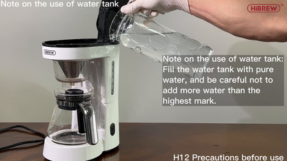 HiBREW H12 white drip coffee maker: filling the rear water reservoir with the glass carafe; full original manufacturer camera scene