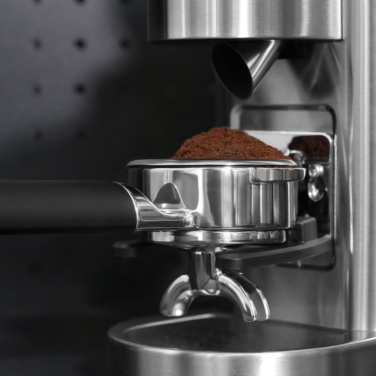 HiBREW H21 Magician 58mm Portafilter — basket filling under a grinder. Scene props are not included unless quoted.