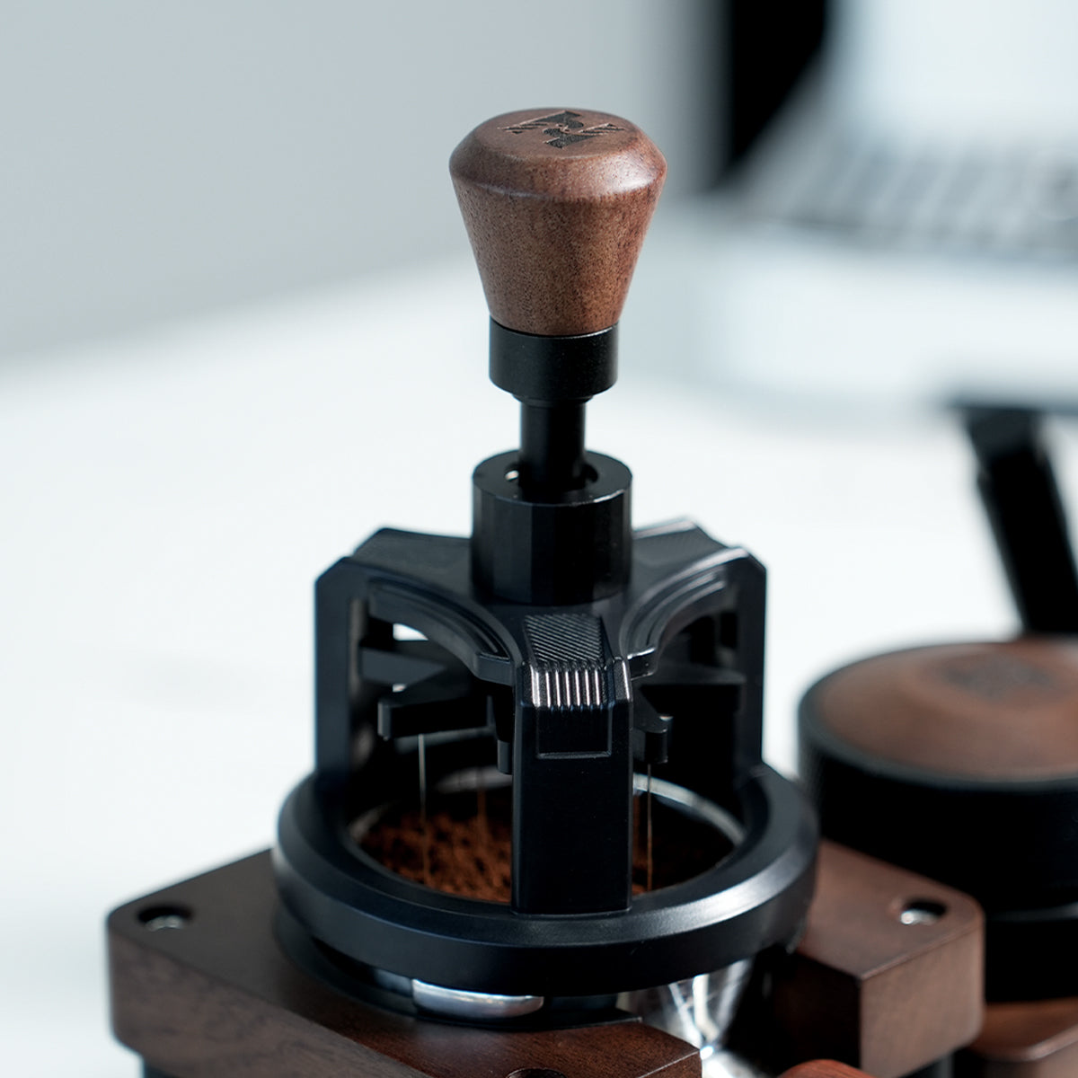HiBREW Rotary 58mm WDT Tool — tool positioned on a coffee basket at a tamping station. Demonstration props are not included.