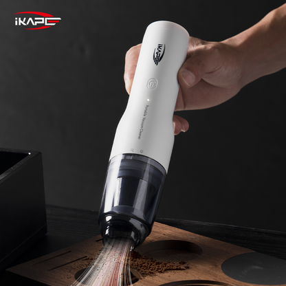 IKAPE White handheld vacuum with a brush attachment cleaning coffee grounds