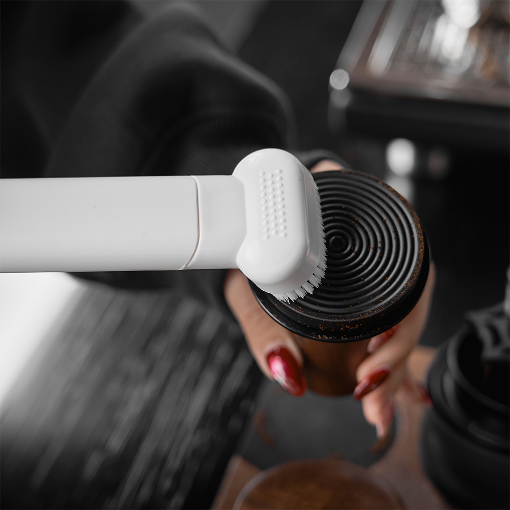 IKAPE White vacuum brush attachment cleaning a coffee grinder component