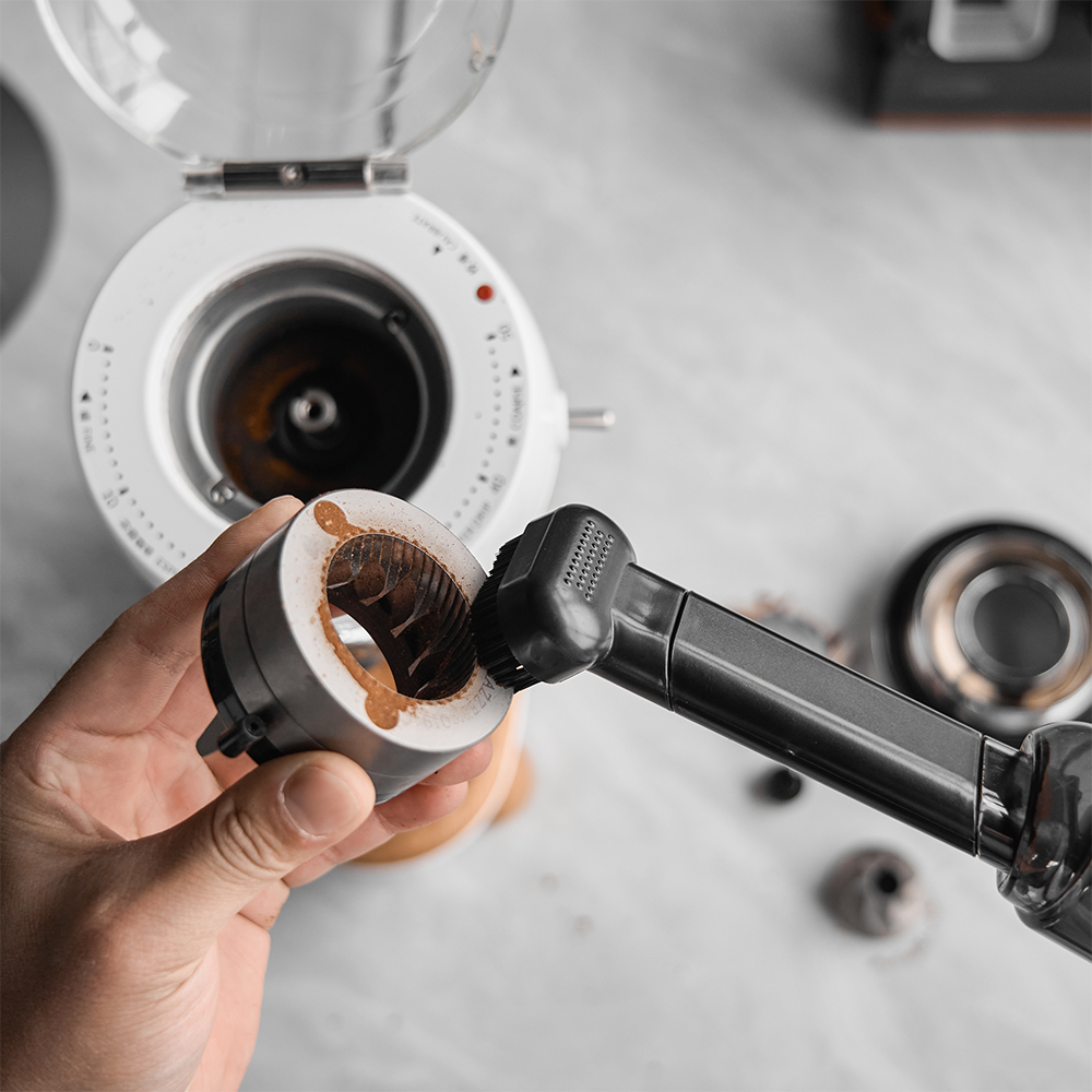 IKAPE handheld vacuum brush attachment cleaning a coffee grinder component
