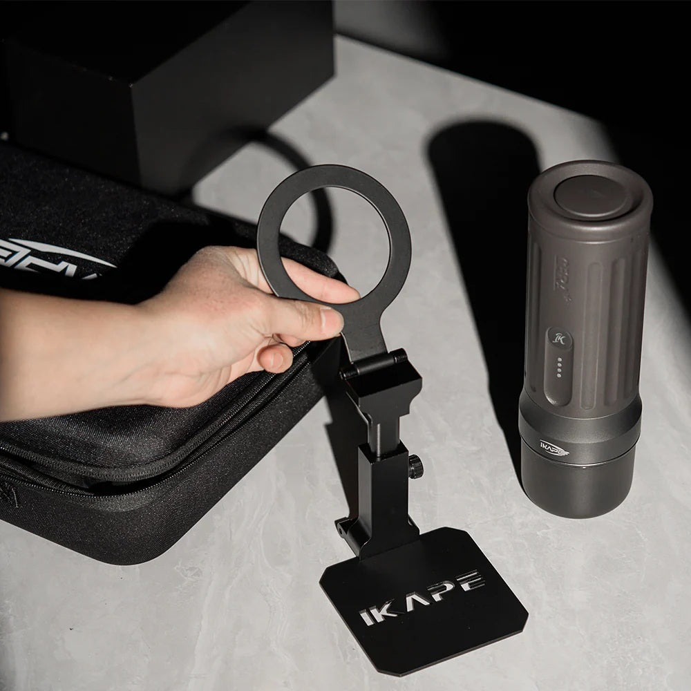 IKAPE black folding coffee maker stand held open, showing its ring, hinge, height adjustment and base