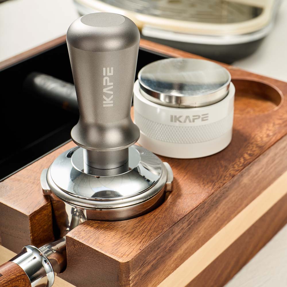 IKAPE V1 organizer supporting a portafilter during tamping
