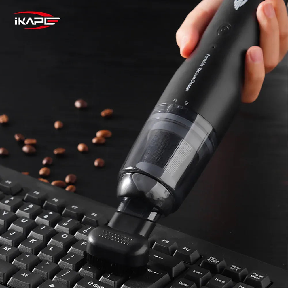 IKAPE Black handheld vacuum with a brush attachment cleaning a keyboard