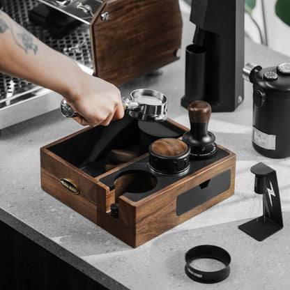 MHW-3BOMBER Walnut CH6624 multifunction knock box in use for coffee-puck disposal; coffee tools and machine are props