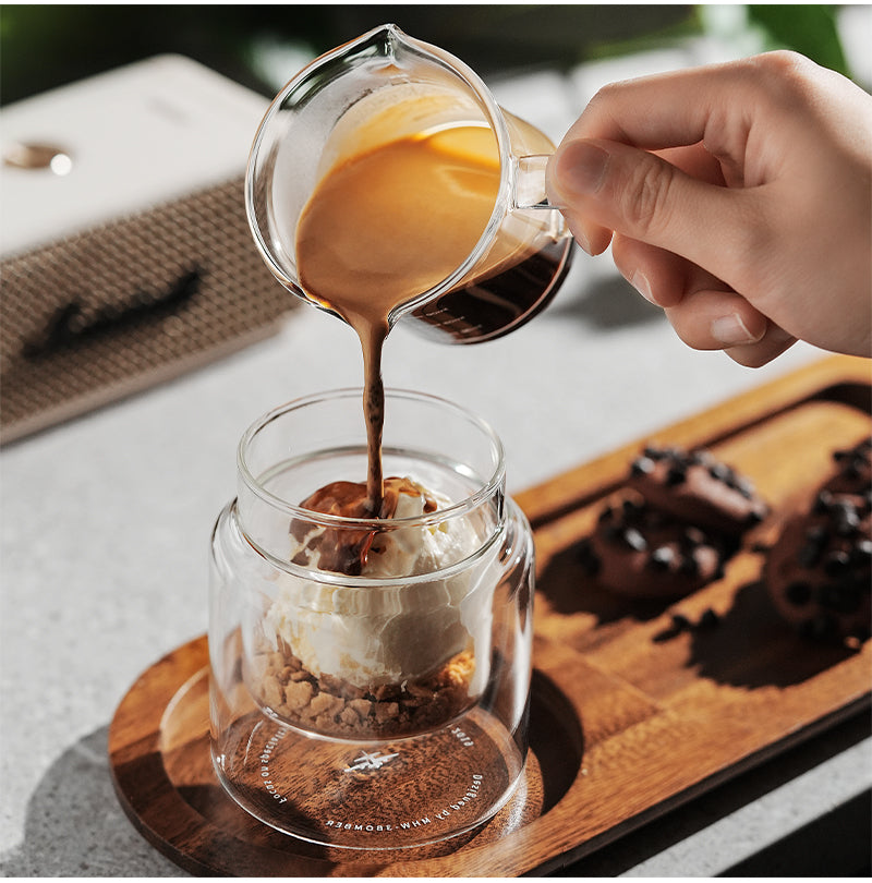 MHW-3BOMBER Clear H-shaped 160 ml DW glass cup receiving coffee on a tray; other items are props