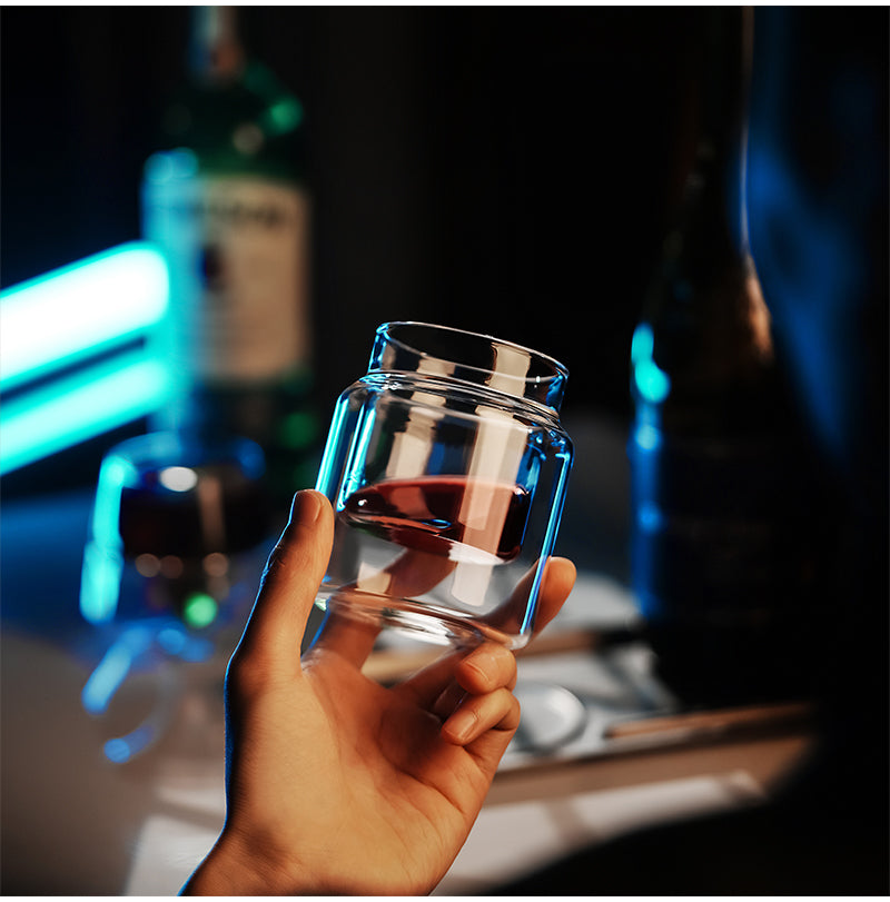 MHW-3BOMBER Clear H-shaped 160 ml DW glass cup held against a blue background