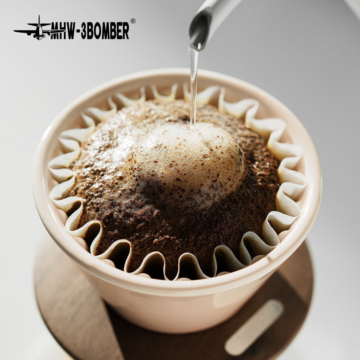 MHW-3BOMBER Lotus Pink dripper during pouring, close view; paper and coffee are serving props