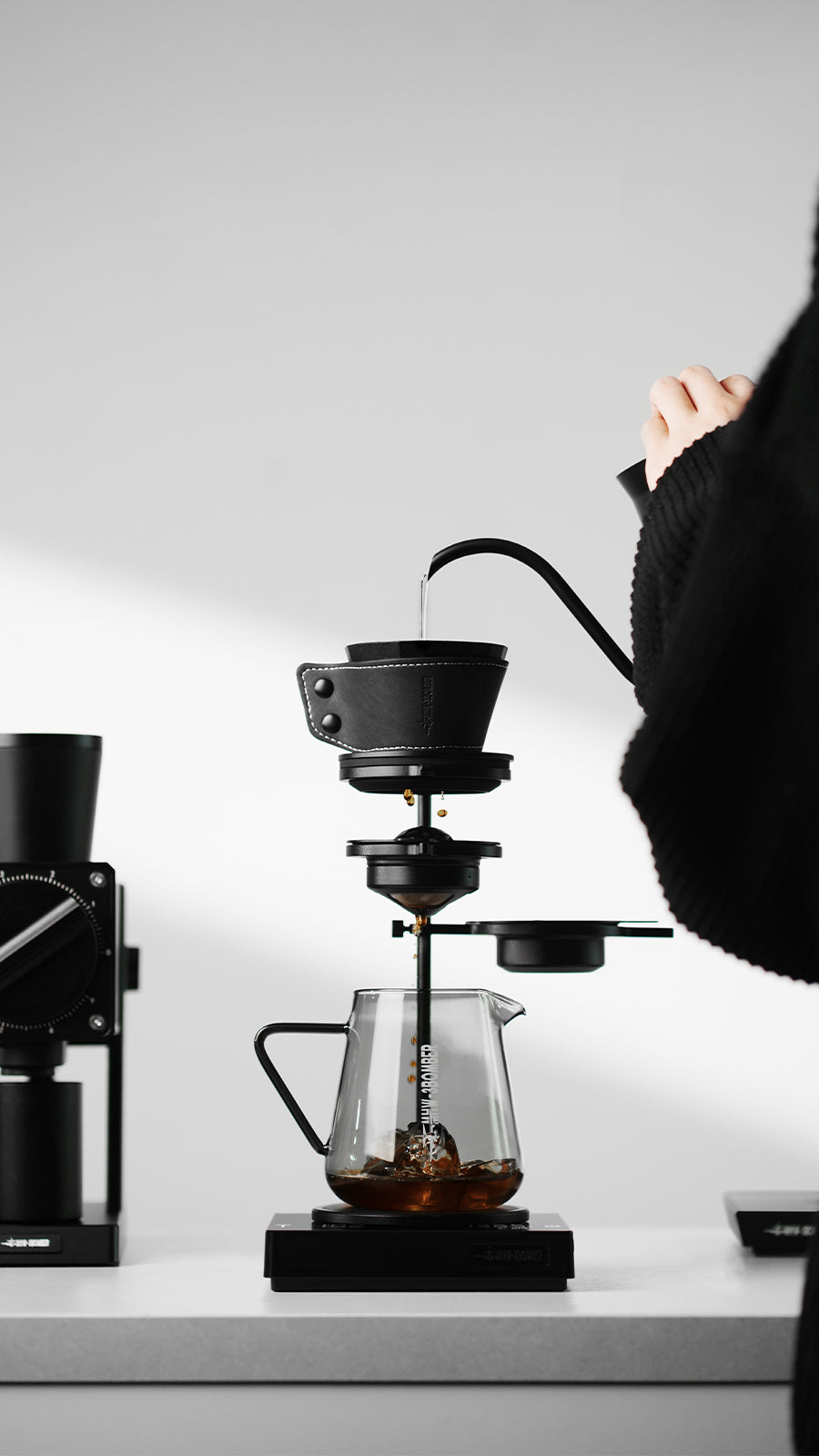 MHW-3BOMBER Obsidian Black stand supporting a pour-over setup, side view