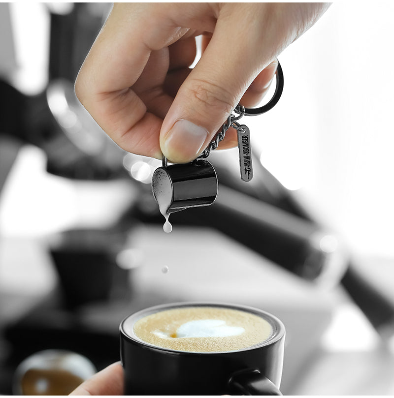 KC5700 milk-pitcher-shaped keychain shown beside a coffee.