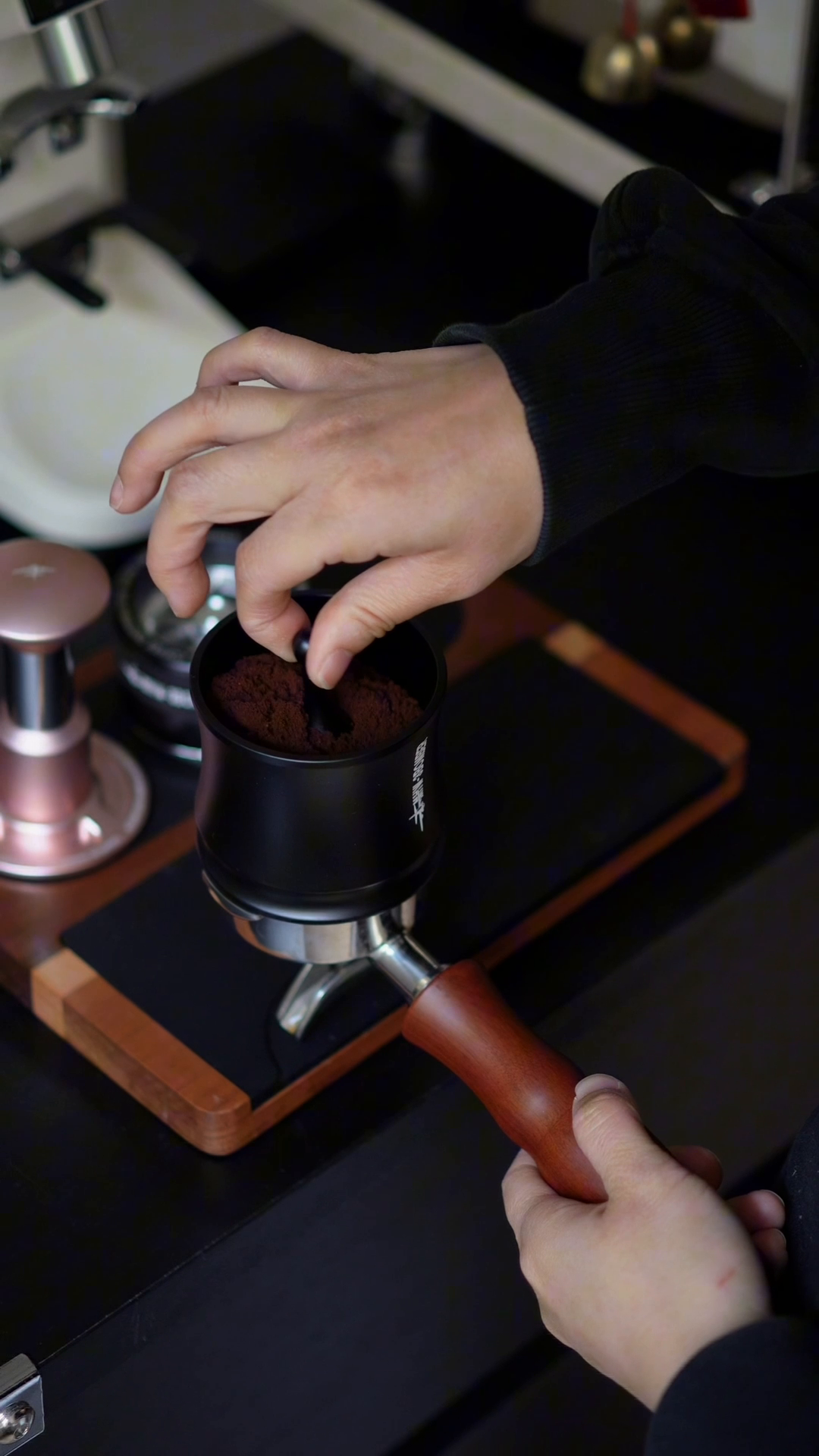 MHW-3BOMBER DR7031B Titanium Black FlowLight cup on a portafilter while lifting the centre rod; portafilter and tamper not included
