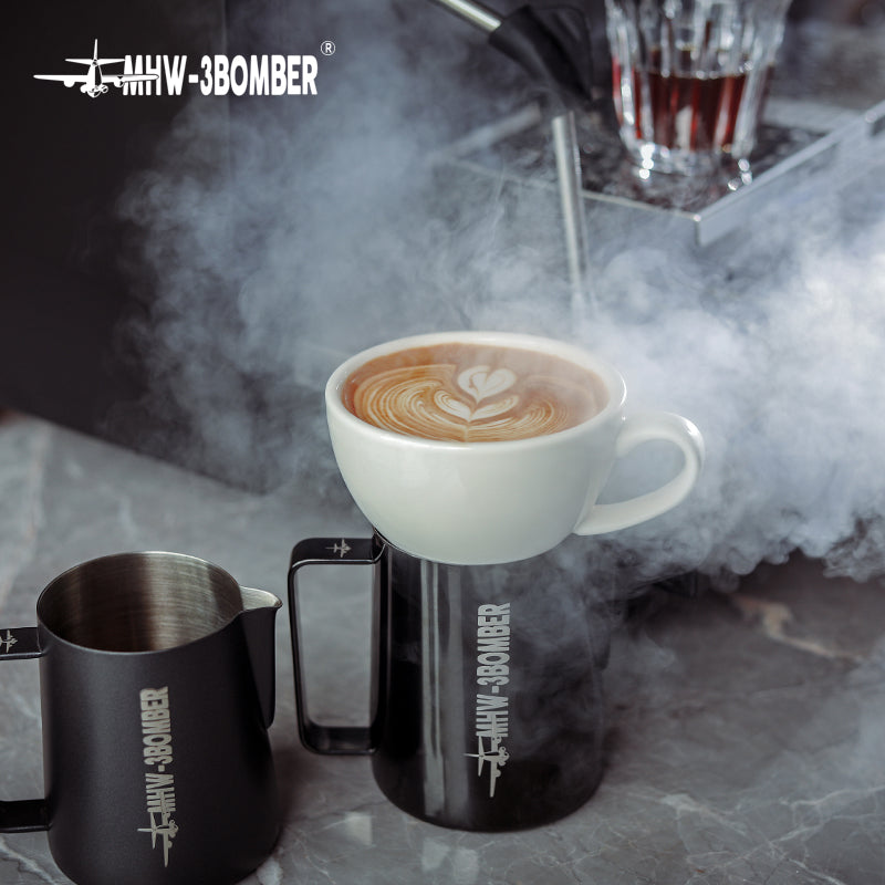 MHW-3BOMBER C5080W Beige White 280 ml latte cup with latte art in a serving scene; pitchers and coffee are photo props.