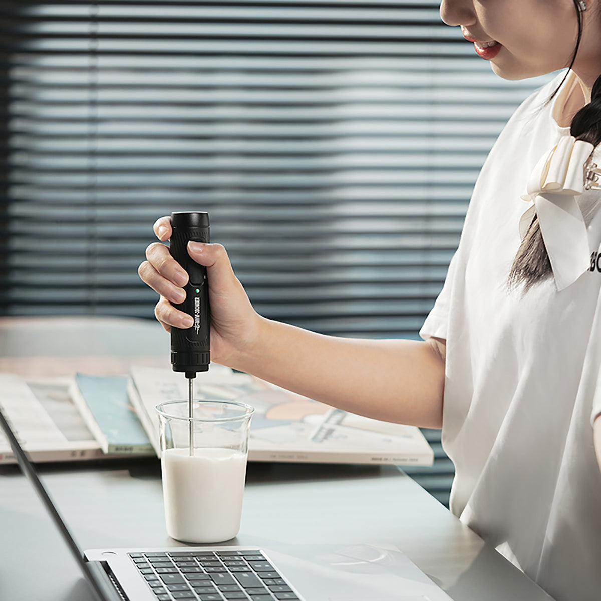 MHW-3BOMBER MF5893 black handheld milk frother being used with milk