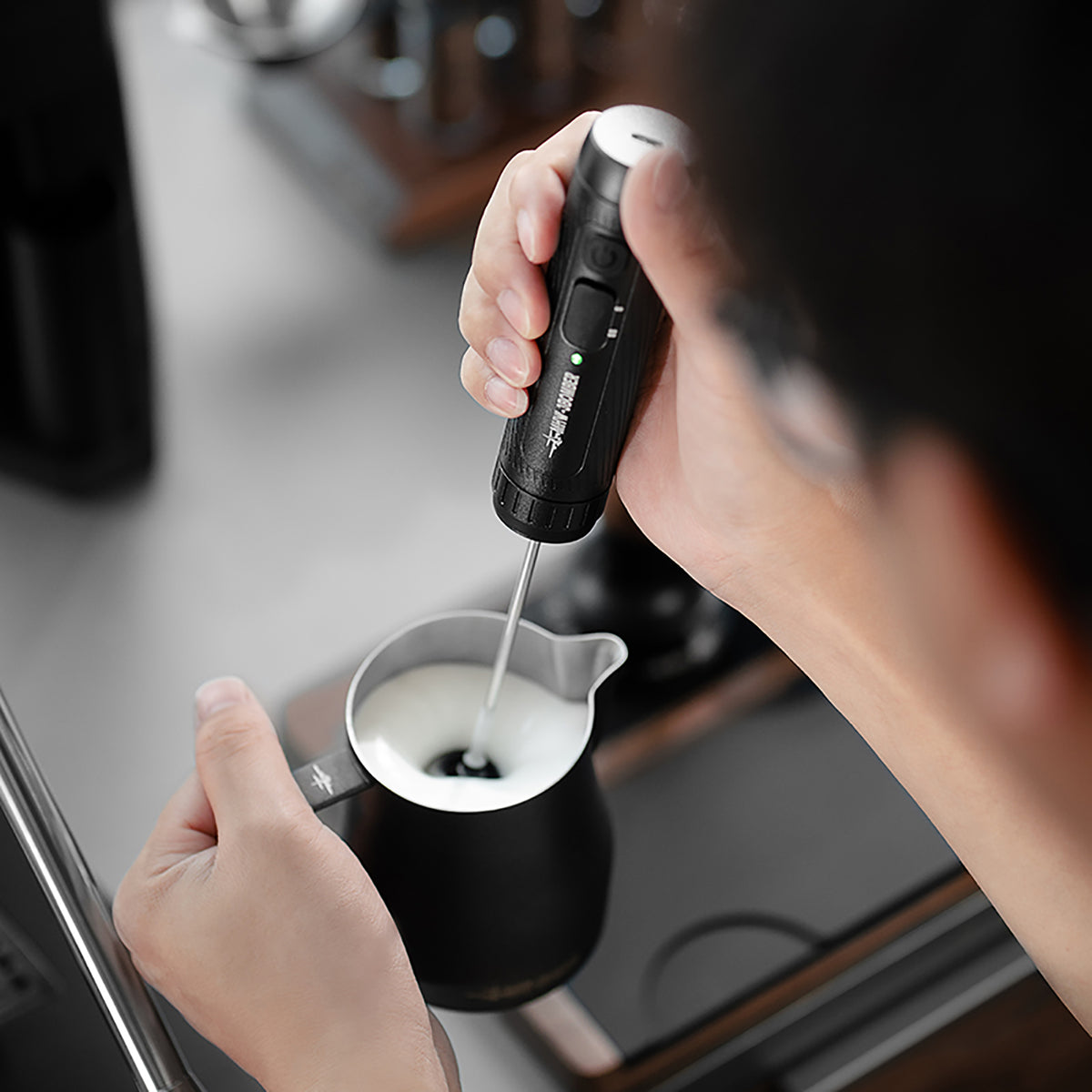 MHW-3BOMBER MF5893 black handheld milk frother in use with milk