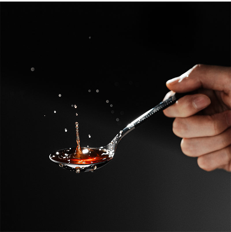 MHW-3BOMBER black and silver cupping spoon lifting coffee