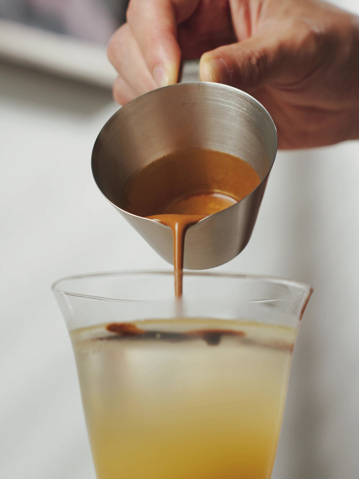 MHW-3BOMBER G5140 satin single-spout measuring cup pouring espresso into a mixed drink