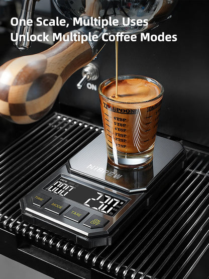 HiBREW black 1000g coffee scale — Black four-button scale beneath an espresso machine spout; machine and cup excluded.