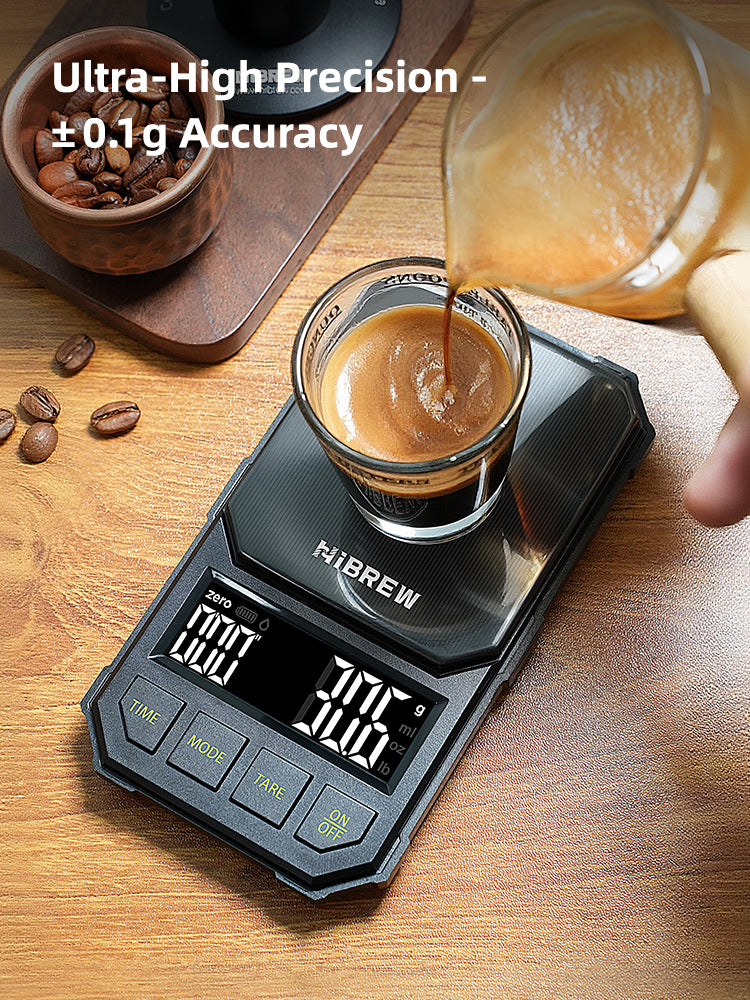 HiBREW black 1000g coffee scale — Black four-button scale during pouring into an espresso cup; cup and pitcher excluded.