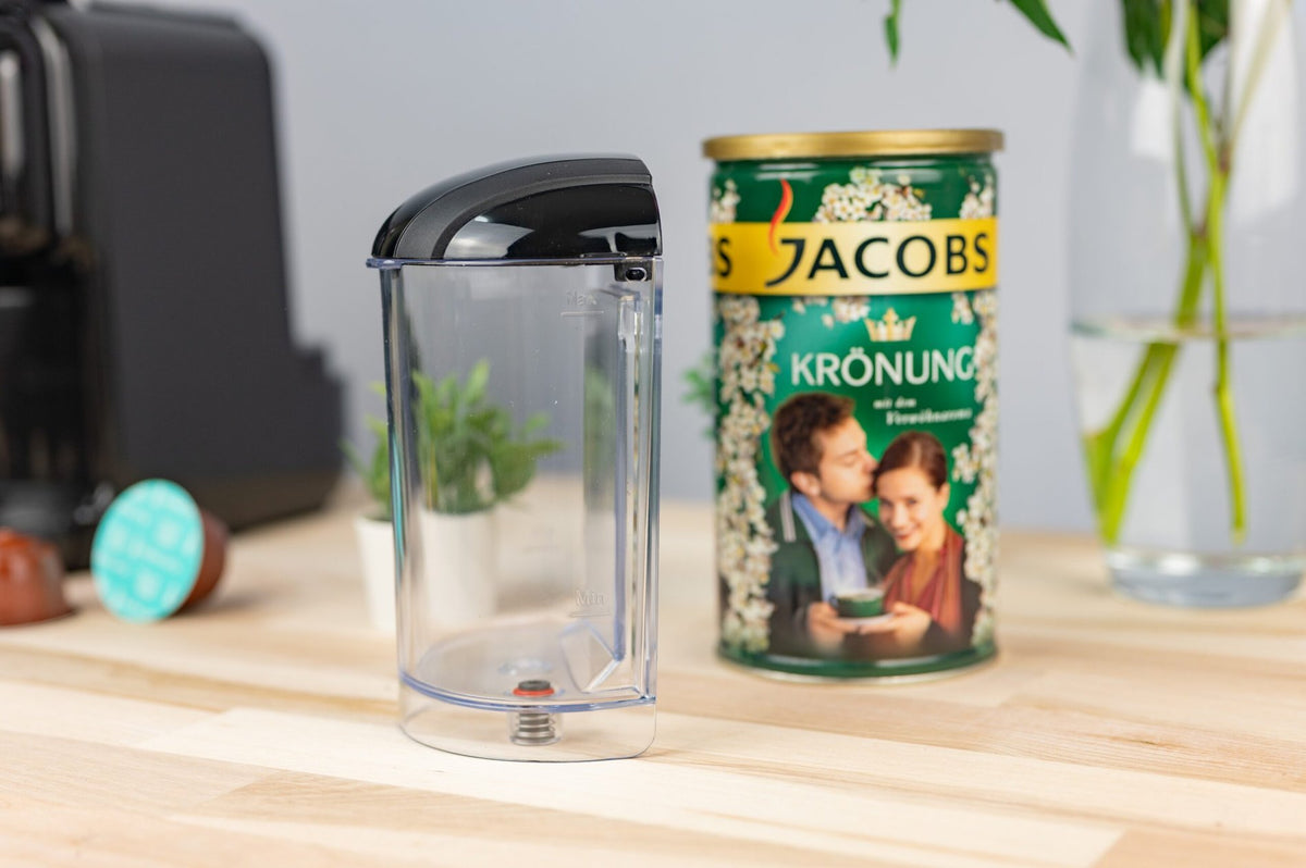 HiBREW H2B removable transparent water tank beside the Black coffee machine; coffee tin is a scene prop