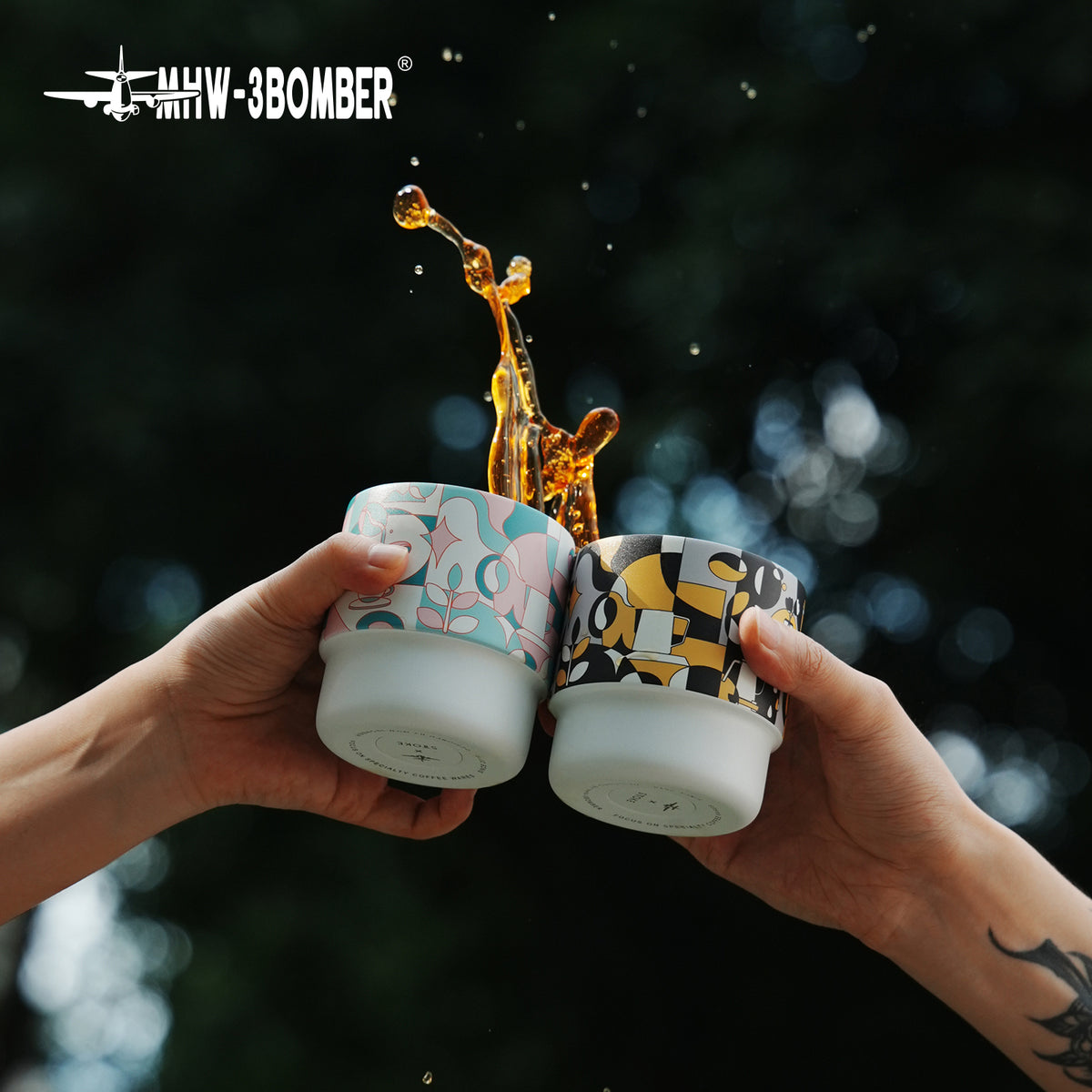 MHW-3BOMBER DW6909BY Black Gold and DW6908PG Pink Green Swirl Cups — two listed artworks in a drink scene