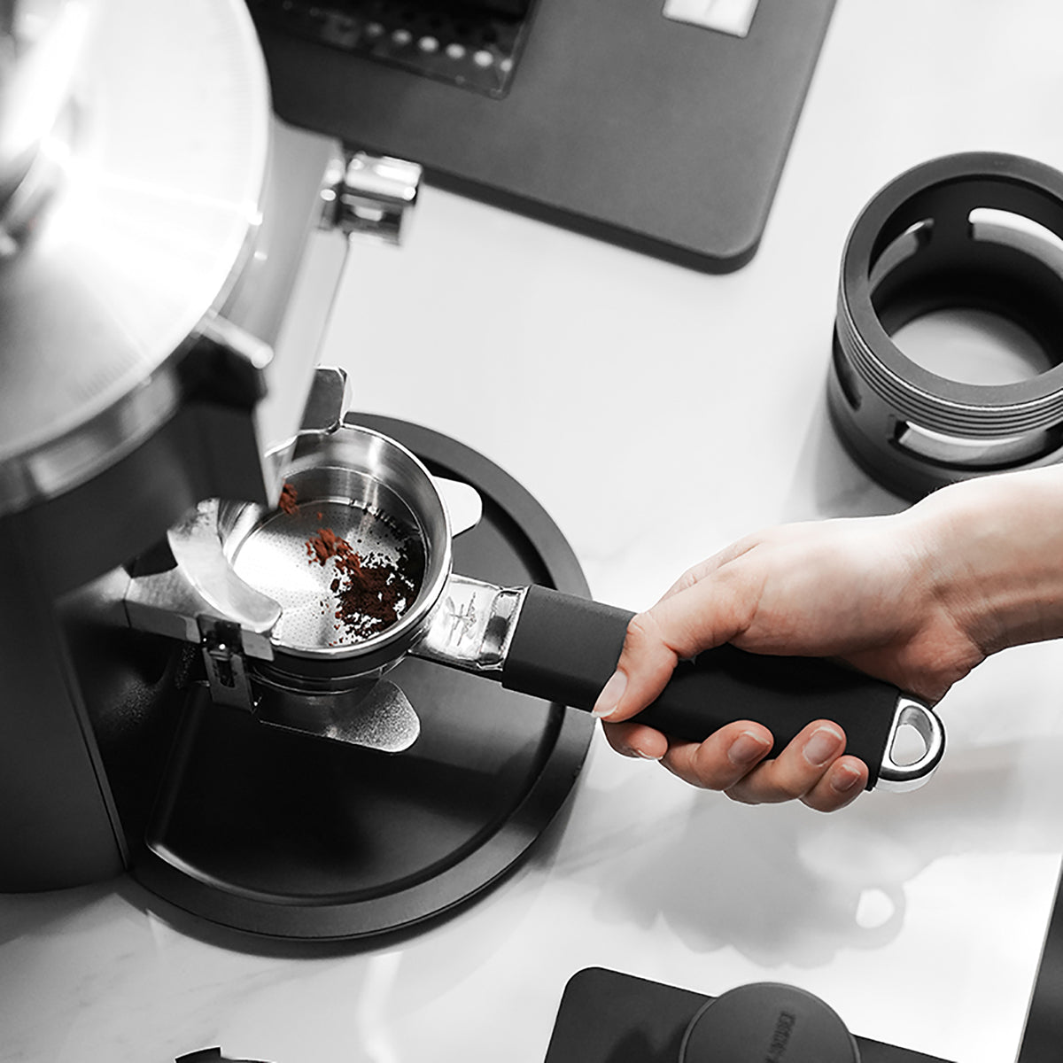 MHW-3BOMBER T5879 Yu one-piece bottomless portafilter receiving coffee grounds, overhead view; grinder and dosing ring not included