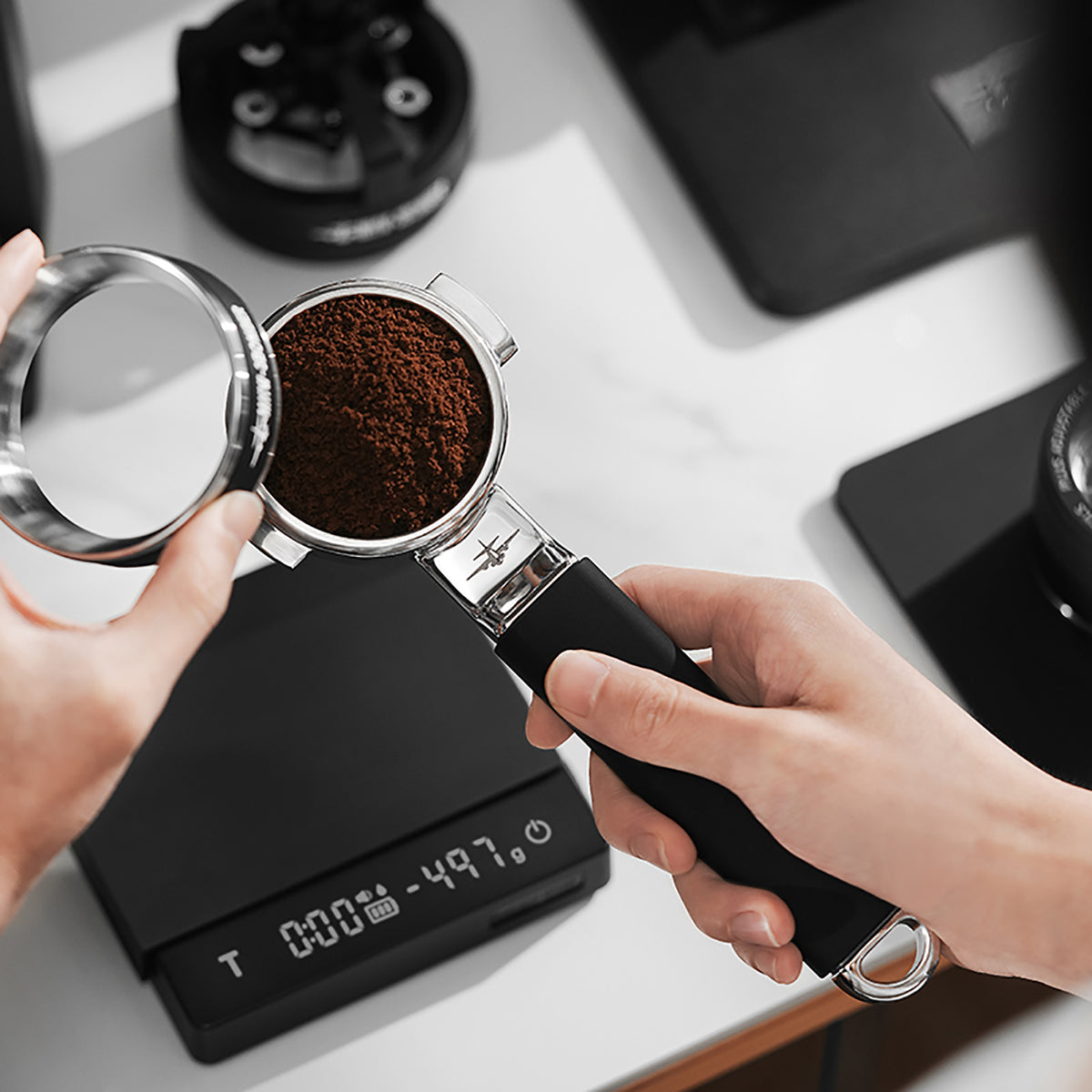 MHW-3BOMBER T5879 Yu one-piece bottomless portafilter during coffee preparation; scale and lid are scene props, not net-weight evidence