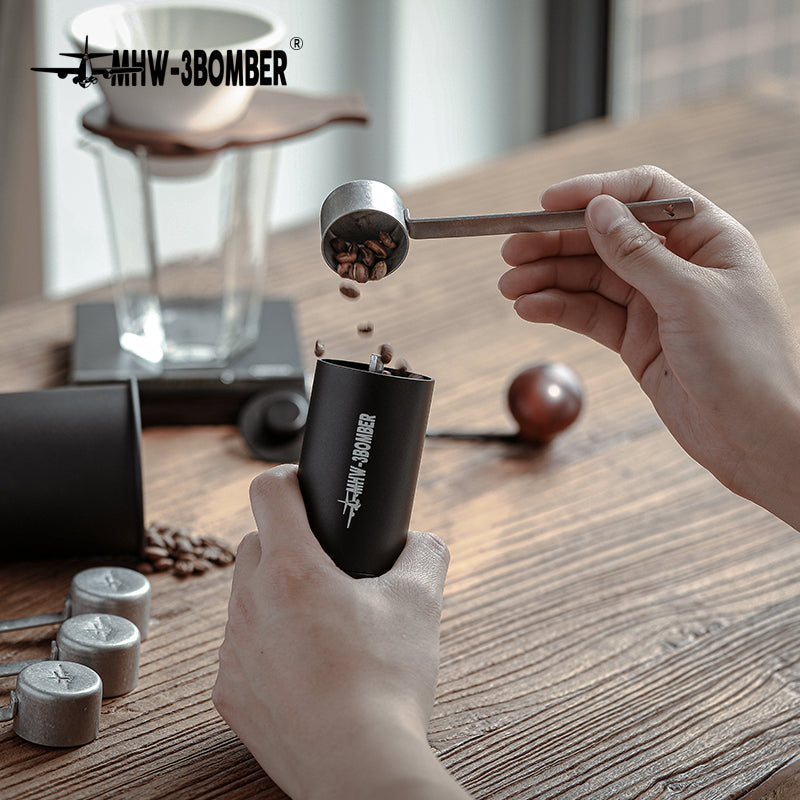 MHW-3BOMBER MS5438 silver-spot long measuring spoon used beside a coffee grinder; grinder is a scene prop