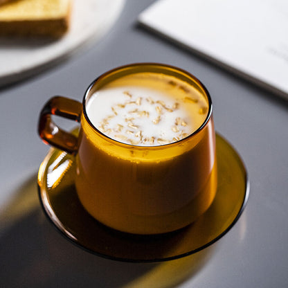 Circle Joy CJ-CF01 matched amber cup and round saucer — overhead oat-milk serving scene. Beverage, food and table props are not included.
