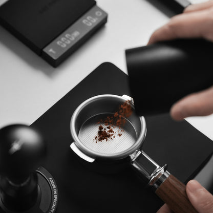 MHW-3BOMBER FB6725 Natural 18g basket during dosing; portafilter and grinder are demonstration equipment