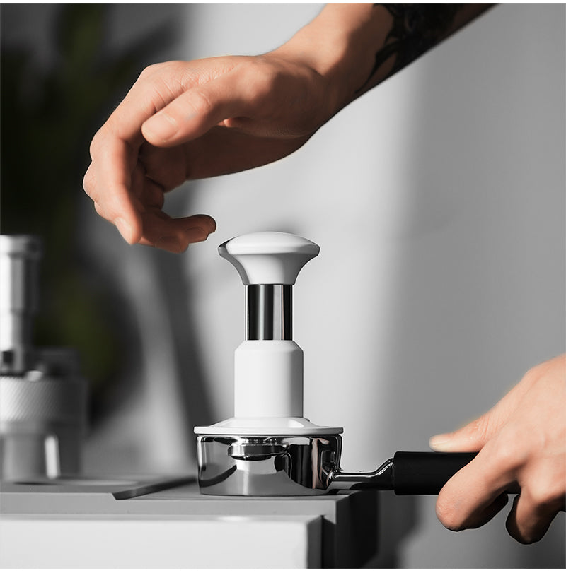 White 58.35 mm Knight Impact Tamper front operating view; basket and station are photo props
