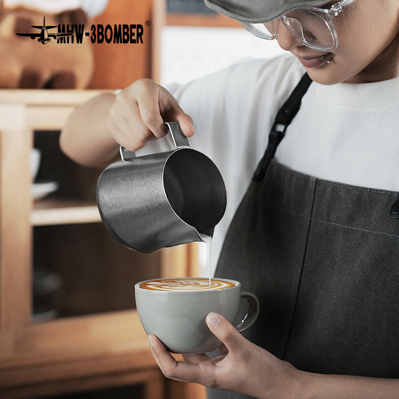 MHW-3BOMBER P5183 GT milk pitcher — 600 ml silver speckle, pouring into a cup. Cups, machines and scene items are not included.
