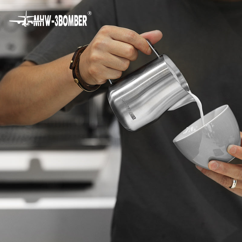 MHW-3BOMBER P6001S Turbo milk pitcher — glossy 450 ml pouring into a tilted white cup. Cups, machines and other scene items are not included.