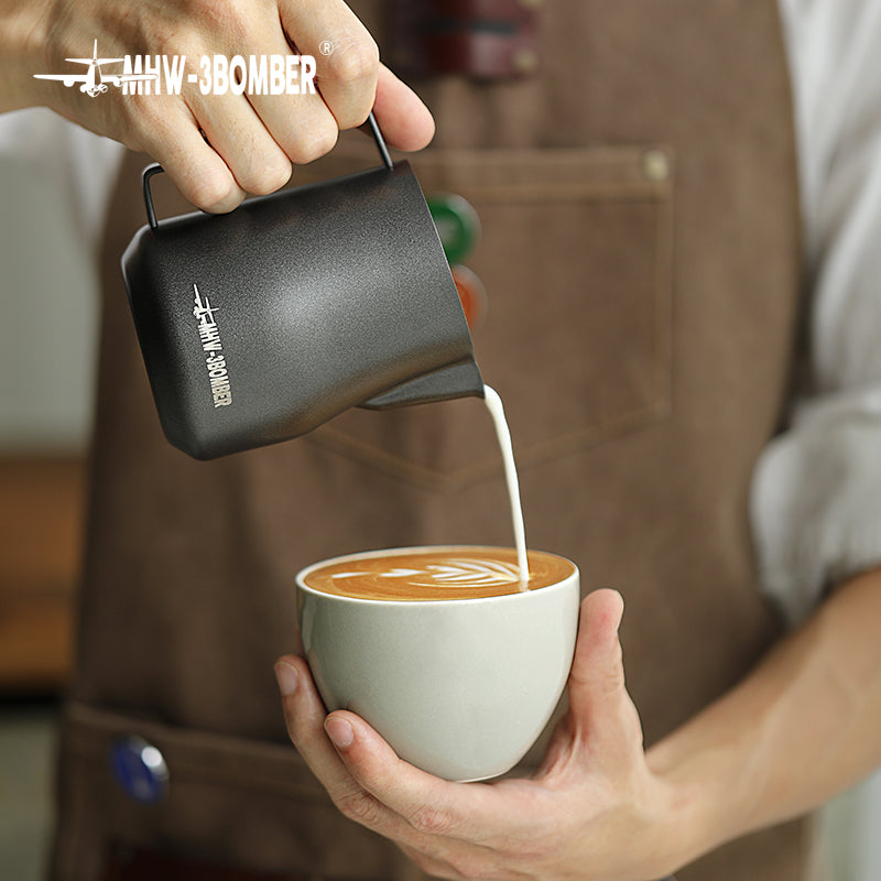 MHW-3BOMBER P6005MB Turbo milk pitcher — matte black 450 ml pouring into a cup. Cups, machines and other scene items are not included.